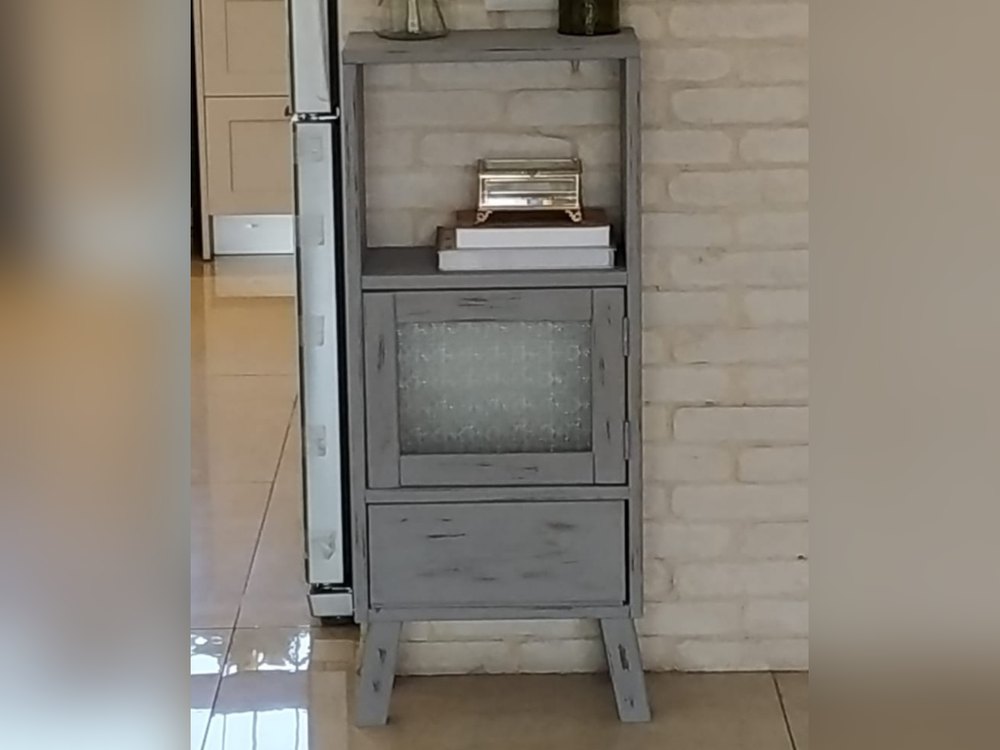 ארונית אפורה על רגליים עם מדף פתוח, דלת זכוכית ומגירה