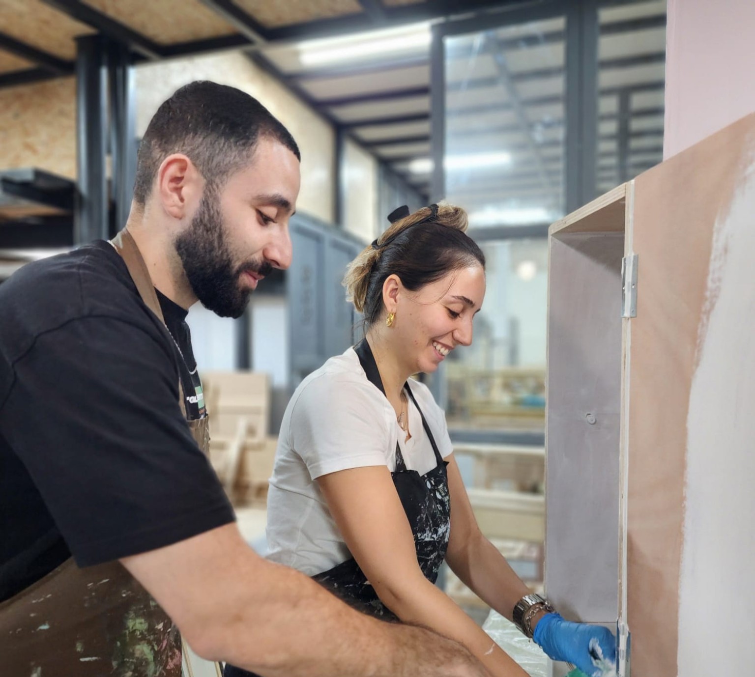 זוג צובע רהיט בסדנת נגרות זוגית